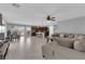 Spacious open-plan living room with tile flooring, a ceiling fan, and a comfortable sectional sofa at 1606 Wild Grain Ave, North Las Vegas, NV 89086