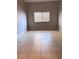 Empty bedroom featuring tile floors, and window with blinds offering neutral space at 1655 Morse Arberry Ave, Las Vegas, NV 89106