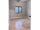 Neutral bedroom featuring tile floors, baseboards and window with blinds for natural light at 1655 Morse Arberry Ave, Las Vegas, NV 89106