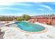 Private backyard pool with rock waterfall feature, stone patio, and lush landscaping at 1830 E Fuchsia St, Pahrump, NV 89048