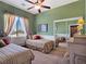 Charming bedroom featuring two twin beds, complemented by natural light and a ceiling fan at 1830 E Fuchsia St, Pahrump, NV 89048