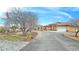 Inviting desert home with circular driveway, stone landscaping, and well-manicured lawn at 1830 E Fuchsia St, Pahrump, NV 89048