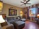 Comfortable living room features a ceiling fan, mirror, large sofa, and wood-style floors at 1830 E Fuchsia St, Pahrump, NV 89048