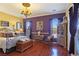 Elegant bedroom with hardwood floors, chandelier, and ornate furnishings exudes sophistication at 1830 E Fuchsia St, Pahrump, NV 89048