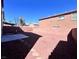 A spacious backyard with gravel and low brick walls offering potential for landscaping at 2316 Cockatoo Dr, North Las Vegas, NV 89084