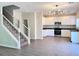 Open floor plan with wood vinyl flooring leading to kitchen with stainless appliances and white cabinets at 2316 Cockatoo Dr, North Las Vegas, NV 89084
