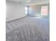 Spacious living room with carpeted floors and natural light from multiple windows at 2316 Cockatoo Dr, North Las Vegas, NV 89084