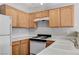 Efficient kitchen with essential appliances, wood cabinets, and bright countertop space at 2621 Adelante Ave # 104, Las Vegas, NV 89106
