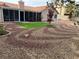 Desert landscaped backyard with a screened in porch, artificial turf, and shade tree at 3316 Cutty Sark St, Las Vegas, NV 89117