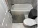 Bathroom with gray tiled floor, new toilet, gray towel and matching neutral decor at 3316 Cutty Sark St, Las Vegas, NV 89117