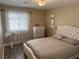 Inviting bedroom featuring wood floors, a tufted headboard, soft decor and natural light from sheer curtained window at 3316 Cutty Sark St, Las Vegas, NV 89117