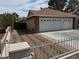 Three car garage with white doors, tile roof and brick accents, complimented by desert landscaping at 3316 Cutty Sark St, Las Vegas, NV 89117