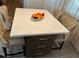 A bright kitchen island features a marble countertop and brown cabinetry, complemented by comfortable seating at 3316 Cutty Sark St, Las Vegas, NV 89117