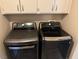 Modern laundry area with front-loading washer and dryer in a well-lit space with upper cabinets at 3316 Cutty Sark St, Las Vegas, NV 89117