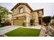 Two-story home featuring a two-car garage, arched windows, red front door and manicured lawn at 3916 Broad Meadow Ct, Las Vegas, NV 89129