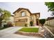 Two-story home featuring a two-car garage, arched windows, red front door and manicured lawn at 3916 Broad Meadow Ct, Las Vegas, NV 89129