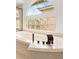 Close-up of a large soaking tub with a modern faucet and a glass block window at 4195 Balmoral Castle Ct, Las Vegas, NV 89141