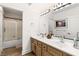 Bright bathroom with double sinks and a glass-enclosed shower, with wood look floors, perfect for a modern lifestyle at 4195 Balmoral Castle Ct, Las Vegas, NV 89141
