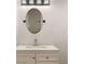 Well-lit bathroom featuring a stylish oval mirror and a modern vanity with marble countertop at 4195 Balmoral Castle Ct, Las Vegas, NV 89141