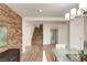Open-concept dining room featuring a stone accent wall and hardwood floors adjacent to stairs at 4195 Balmoral Castle Ct, Las Vegas, NV 89141