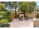 Cozy outdoor fireplace with comfortable seating in a private backyard setting near the pool at 4195 Balmoral Castle Ct, Las Vegas, NV 89141