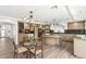 Elegant kitchen featuring a large island, modern lighting, and stainless steel appliances at 4195 Balmoral Castle Ct, Las Vegas, NV 89141