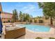 Gorgeous swimming pool with a baja shelf, surrounded by well-manicured landscaping and patio seating at 4195 Balmoral Castle Ct, Las Vegas, NV 89141