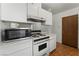 Compact kitchen featuring white cabinetry, gas range, microwave, and linoleum flooring at 420 Altamira Rd, Las Vegas, NV 89145