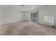 Spacious living room featuring neutral carpet, white walls and sliding glass door at 420 Altamira Rd, Las Vegas, NV 89145