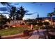 Charming backyard features a lush lawn, desert landscaping, fire pit, and quaint fountain at 442 Beardsley Cir, Henderson, NV 89052