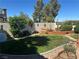 Green backyard with a built-in BBQ, mature shrubbery, and nice perimeter wall at 442 Beardsley Cir, Henderson, NV 89052