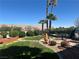 Well-kept backyard featuring a manicured lawn, patio, and mature palm trees at 442 Beardsley Cir, Henderson, NV 89052