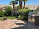 Inviting backyard with a built-in grill, tiled patio, and mature landscaping at 442 Beardsley Cir, Henderson, NV 89052