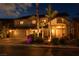Inviting two-story home with a three-car garage, desert landscaping, and a red tile roof illuminated at night at 442 Beardsley Cir, Henderson, NV 89052