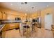 Bright eat-in kitchen featuring stainless appliances, a breakfast bar, tile floors, and light wood cabinetry at 442 Beardsley Cir, Henderson, NV 89052