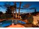 Backyard pool and attached jacuzzi with stone surround, desert landscaping, and mature palm trees at 442 Beardsley Cir, Henderson, NV 89052