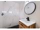 Modern bathroom featuring a stylish vanity, round mirror, and marble tile in the walk-in shower at 5129 Del Monte Ave, Las Vegas, NV 89146