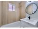 Modern bathroom features a bathtub shower combination with decorative tiled wall and vanity with a round mirror at 5129 Del Monte Ave, Las Vegas, NV 89146