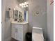 Stylish powder room featuring a modern vanity, decorative mirror and light fixture, and contemporary decorative wall accents at 5518 Stormy Night Ct, Las Vegas, NV 89120