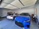 Well-lit two-car garage with epoxy floors, equipped with modern vehicles and additional space for storage at 5518 Stormy Night Ct, Las Vegas, NV 89120