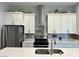 Modern kitchen features stainless steel appliances, white cabinetry, and quartz countertops at 5518 Stormy Night Ct, Las Vegas, NV 89120
