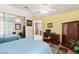 Inviting bedroom with a ceiling fan, desk, and mirror reflecting a second bed at 5709 Colwood Ln, Las Vegas, NV 89130
