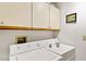 Convenient laundry room with washer, dryer, and overhead storage cabinets at 5709 Colwood Ln, Las Vegas, NV 89130