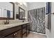 Modern bathroom features a dual sink vanity with granite countertop and dark wood cabinetry at 6312 Monarch Creek St, Las Vegas, NV 89130