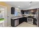 Kitchen with stainless steel appliances, dark cabinetry, and a window with natural light at 6312 Monarch Creek St, Las Vegas, NV 89130