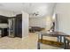 Spacious open-concept living area adjacent to the kitchen with tile flooring and grey sofa at 6312 Monarch Creek St, Las Vegas, NV 89130