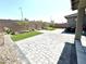 A large backyard featuring brick pavers, a block wall, minimal landscaping, and a motorcycle at 6436 Linden St, North Las Vegas, NV 89086