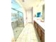 Bright Primary bath with dual sinks, white tile floors, and large glass enclosed shower at 6436 Linden St, North Las Vegas, NV 89086