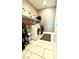 Functional laundry room with tile flooring, washer, dryer, and storage shelving for organization at 6436 Linden St, North Las Vegas, NV 89086