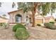 Inviting front yard with lush landscaping, rock features, and a mature shade tree at 672 Hitchen Post Dr, Henderson, NV 89011